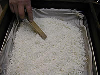 枠に布巾を敷き、砕いたもち米をあけて平らにならし、約30分強火で蒸します